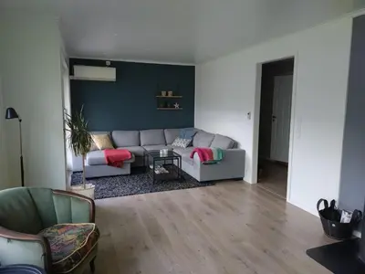 a living room with a couch and a table at Koselig hus med flott utsikt in Vossevangen