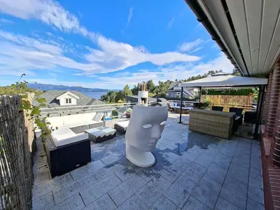 a patio with a white head sculpture on a roof at Villa with lake view in Lunde