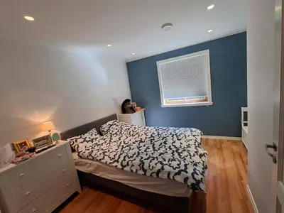 a bedroom with a bed and a blue wall at Villa with lake view in Lunde