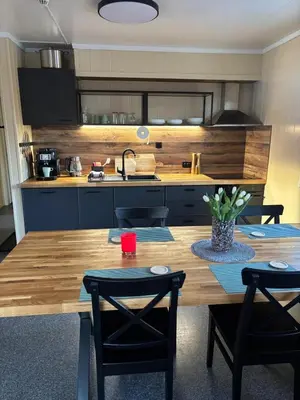 a kitchen with a wooden table and some chairs at Martini Fishing Camp in Lauvsnes