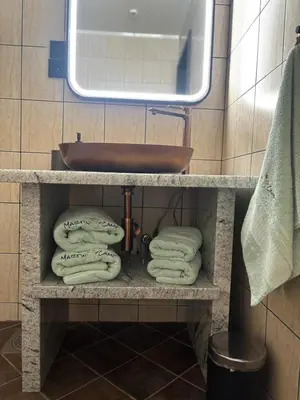 a bathroom with a sink and towels on a shelf at Martini Fishing Camp in Lauvsnes