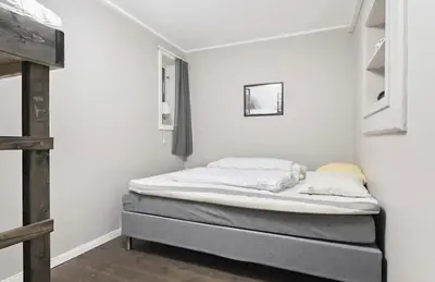a bed in a room with white walls at Mountain apartment Norefjell Ski in ski out in Surteberg