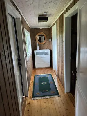 a hallway of a tiny house with a rug on the floor at Cozy lakeside cabin in Trøndelag