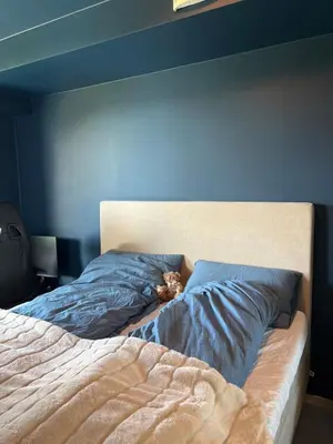 a bed with a teddy bear laying on top of it at Modern apartment with view in Lii