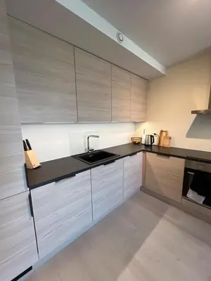a kitchen with white cabinets and black counter tops at Modern apartment with view in Lii