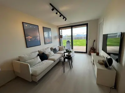 a living room with a white couch and a tv at Modern apartment with view in Lii