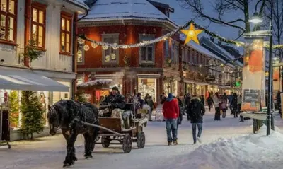 a horse drawn carriage on a snowy street with people at Flora in Lillehammer