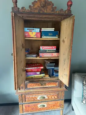 a wooden book shelf with books in it at Fossen bratte chalet in Eikedalen