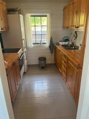 a kitchen with wooden cabinets and a sink at Cottage by the lake in Namsos in Fosslandsosen