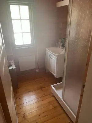 a bathroom with a white sink and a shower at Cottage by the lake in Namsos in Fosslandsosen