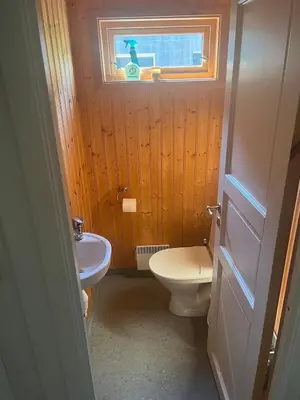 a bathroom with a toilet and a sink and a window at Cottage by the lake in Namsos in Fosslandsosen