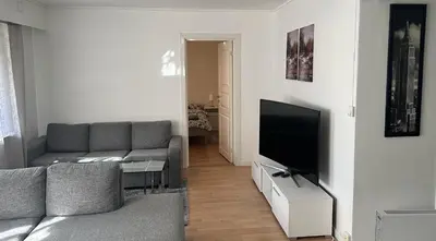 a living room with a couch and a flat screen tv at Koselig 3 roms leilighet på Rjukan in Øverland