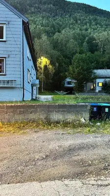 a house and a road next to a building at Koselig 3 roms leilighet på Rjukan in Øverland