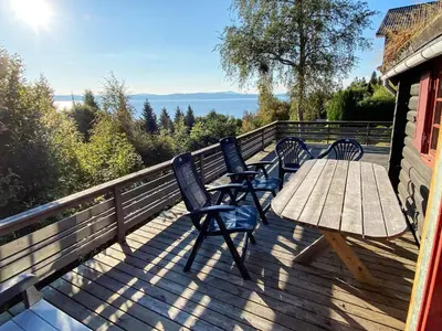 a deck with a wooden table and chairs on it at 6 person holiday home in LEKSVIK in Leksvik
