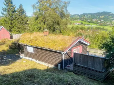 a cabin with a grass roof with a red barn at 6 person holiday home in LEKSVIK in Leksvik