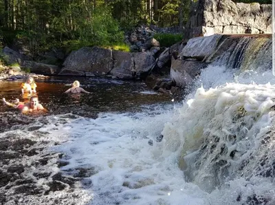 two people swimming in a river with a waterfall at Cabin in Kongsberg, Jondalen in Kongsberg