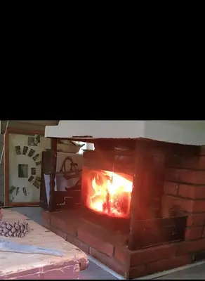 a brick fireplace with a fire in it at Cabin in Kongsberg, Jondalen in Kongsberg