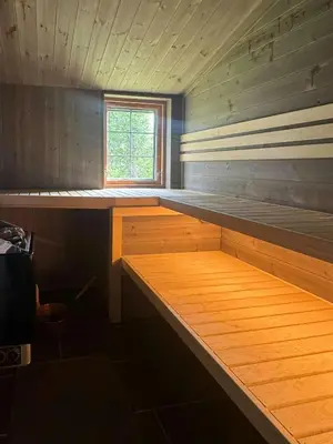 a room with a wooden bed in a room with a window at Cosy Family Cabin With Views And Sauna in Svingvoll