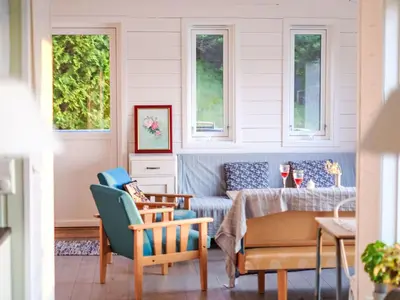 a living room with a couch and chairs and windows at Holiday Home Lauvlid Cottage by Interhome in Tysnes