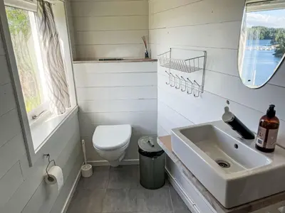 a bathroom with a sink and a toilet and a mirror at Holiday Home Lauvlid Cottage by Interhome in Tysnes