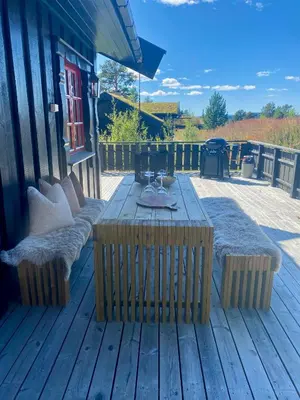 a wooden deck with a table and benches on it at Bjarnebu - 4 bedroom cabin in Rauland in Rauland