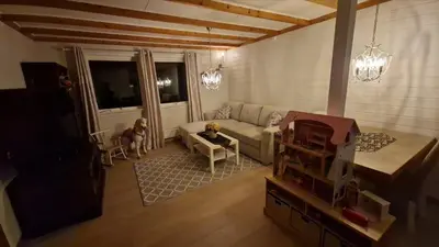 a living room with a couch and a tv at Apartment in peacefull surroundings in Ådnavik