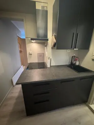 a kitchen with black cabinets and a counter top at The best place to stay in city center - close to everything in Bergen