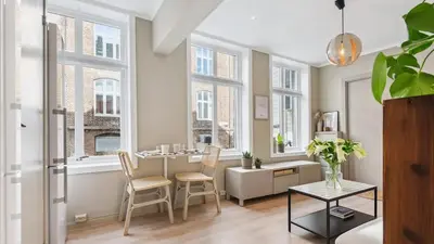 a living room with a table and chairs and windows at The best place to stay in city center - close to everything in Bergen