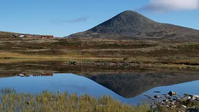 a reflection of a mountain in a body of water at Fiskebu at Flaksjøen in Venabygd