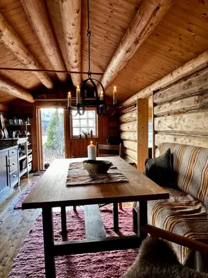 a dining room with a table and a couch at Fiskebu at Flaksjøen in Venabygd