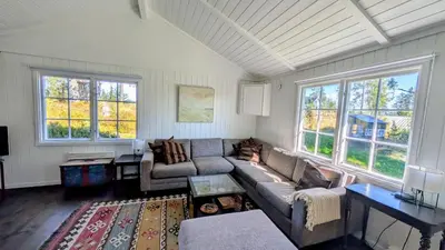 a living room with a couch and two windows at Soltoppen - cozy 3 bedroom cabin close to Norefjell
