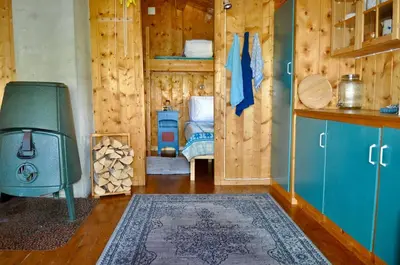 a room with a stove and a room with a bed at Hyggelig fiskebu ved Langrumpa fiskevann in Venabygd