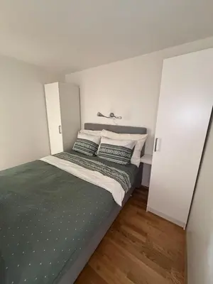 a small bedroom with a bed and white walls at Stay in the middle of Bergen city centre! in Bergen