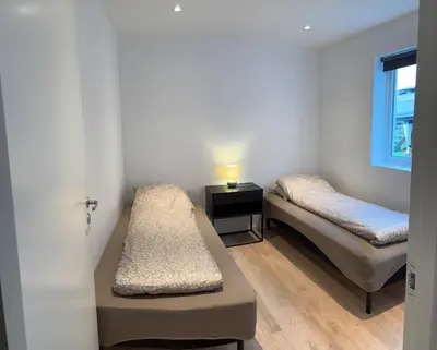 a room with two beds and a window at Large and bright apartment, perfect base in autumn in Ålesund