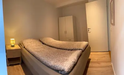 a small bedroom with a bed and a cabinet at Large and bright apartment, perfect base in autumn in Ålesund