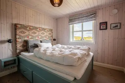 a bedroom with a large bed with a window at Valdreshytte med peis Klassisk og lun stil in Aurdal