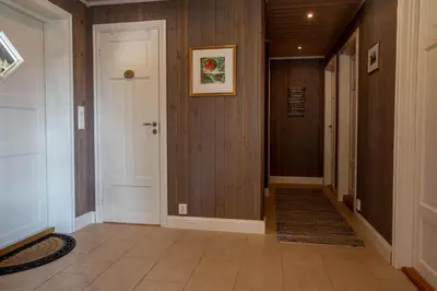 a hallway with a white door and a tile floor at Valdreshytte med peis Klassisk og lun stil in Aurdal