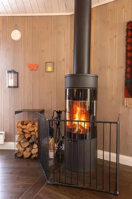 a stove in a room with a pile of logs at Valdreshytte med peis Klassisk og lun stil in Aurdal
