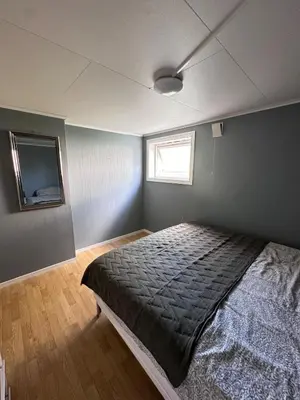 a bedroom with a bed and a window in it at Basement apartment in beautiful Volda in Volda