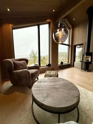 a living room with a table and chairs and a large window at Exclusive cabin with sauna and mountain view in Geilo in Hol