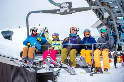 a group of people sitting on a ski lift at The Blue Cabin in Trysil