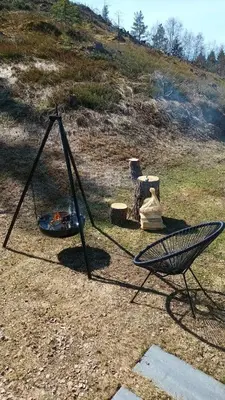 a swing and a chair in a field at The Blue Cabin in Trysil