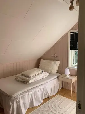 a bed sitting in a room with a window at Bright and nice apartment in Kristiansund