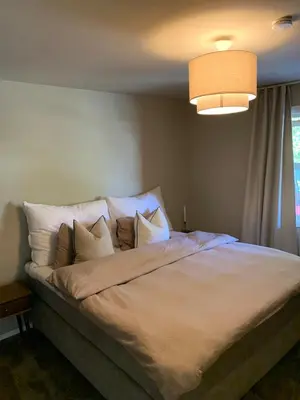 a bedroom with a large bed with white sheets and pillows at Bright and nice apartment in Kristiansund