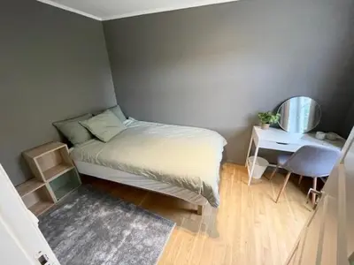 a small bedroom with a bed and a mirror at Koselig leilighet ved Solsiden in Trondheim