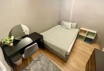 a small bedroom with a bed and a mirror at Koselig leilighet ved Solsiden in Trondheim