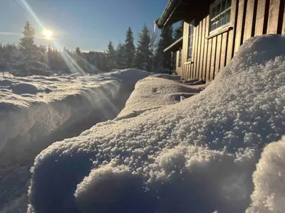 a pile of snow in front of a house at Very central and by the lake Sjusjøen in Ringsaker
