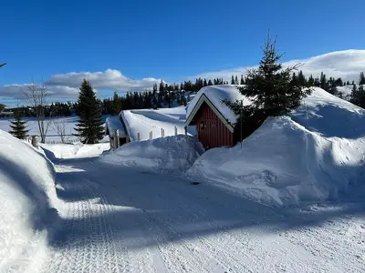 a smallshed covered in snow next to a road at Very central and by the lake Sjusjøen in Ringsaker