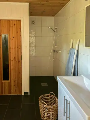 a bathroom with a sink and a mirror and a shower at Cabin With Views Over Straumsundet in Øygarden
