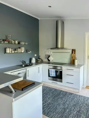 a kitchen with white cabinets and a stove at Cabin With Views Over Straumsundet in Øygarden